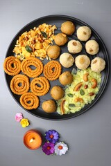 Indian festival food - Diwali Special sweet and salty snacks such as Chakli, Rava laddu, besan ladu, poha chivda, and corn mixture, Namkeen snacks. Diwali Faral from Maharashtra, India. Copy space.