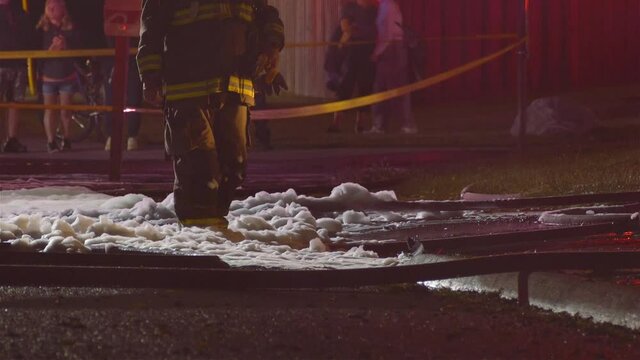 Clip of firemen walking over foam after a blaze