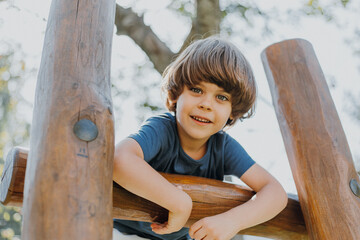 portrait of a smiling little brunette boy in a blue T-shirt playing outdoors. happy child, lifestyle. products for children. High quality photo © Tina kids photo