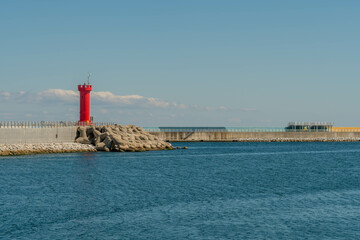 Fototapeta premium Red lighthouse on concrete pier