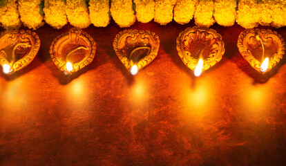 Diwali background with clay Diya lamps and marigold flowers with copy space