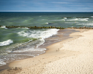 Wooden breakwater on a sandy beach 