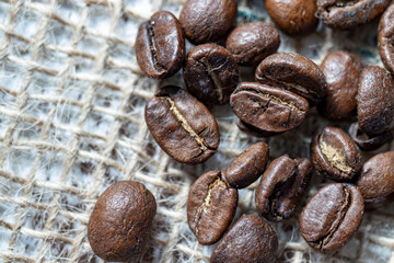 Coffee bean grains standing on straw fabric. macro photo. 