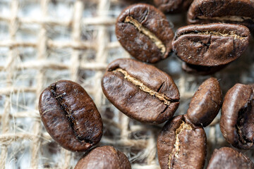 Coffee bean grains standing on straw fabric. macro photo. 