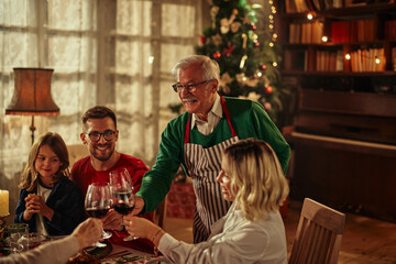 Three generations family celebrating Christmas at home and toasting