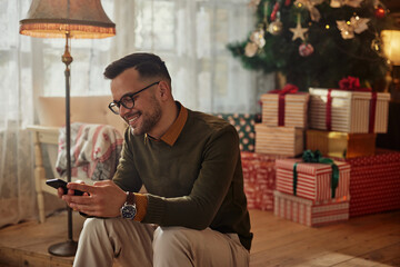 Man using cellphone during Christmastime at home