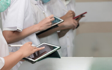 student doctor in white lap coat, hand using stylus pen or electronic pencil learning on digital...