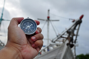 Holding a navigation compass with a harbor atmosphere background