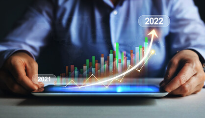 Businessman using tablet with  increase arrow graph corporate future growth year 2021 to 2022..  Business Strategy Development and Growing Growth Plan.