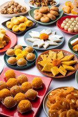 Group of Indian assorted sweets or mithai with diya