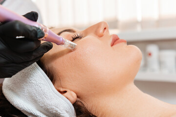 Salon cosmetology. Cosmetologist in protective gloves does procedure of apparatus fractional...