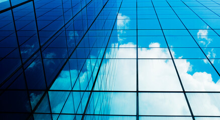 business building in city with mirror windows with reflections of blue sky.