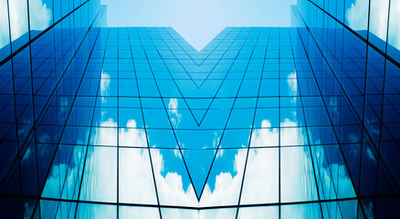 business building in city with mirror windows with reflections of blue sky.