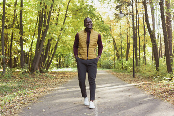 African american student walking in the park in autumn season