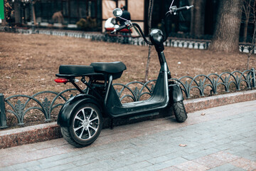 Black electric scooter on the road. Ecological and urban transport in the city