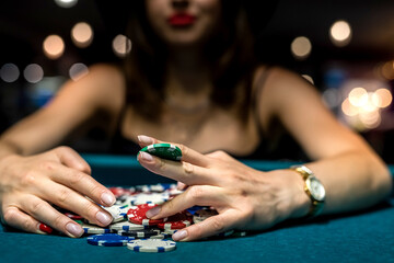pretty woman in evening black dress plays poker in the casino