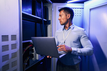 Male technician testing equipment in data center