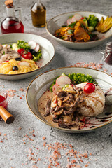 Various gourmet second course dishes on gray background