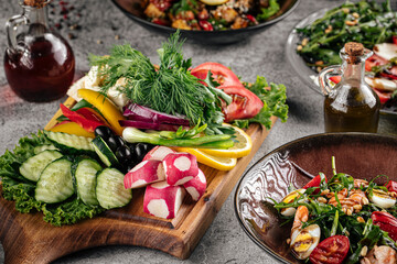 Various restaurant portions of salads on gray background