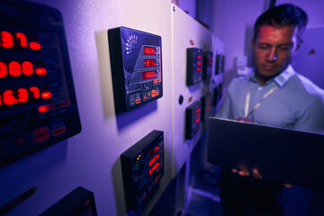 Data center technician monitoring electric power equipment