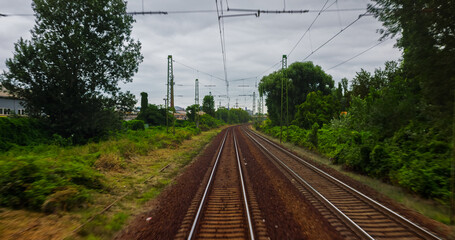 Point of view train travel under cloudy sky