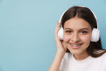 Young woman smiling while listening music with headphones