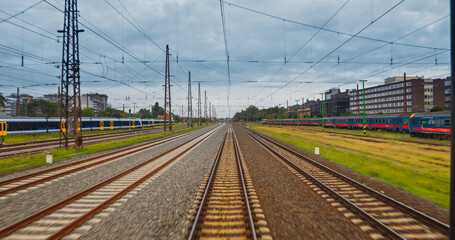 Point of view train travel under cloudy sky