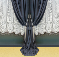 Fragment of decoration in theatrical style. Classic black velvet curtain and white French curtains.