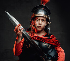 Angry roman little soldier with sword in dark background