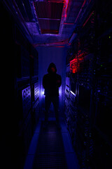 Pensive male hacker in dark server room