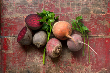 Raw beetroots and parsley on weathered wooden surface