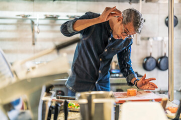 Male chef seasoning food in kitchen