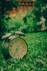 Old clock on green glass in the morning, vintage style