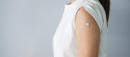 woman showing bandage after receiving covid 19 vaccine. Vaccination, herd immunity, side effect,...