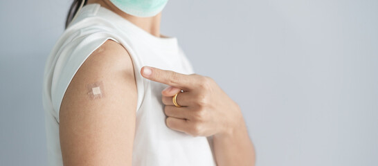 woman showing bandage after receiving covid 19 vaccine. Vaccination, herd immunity, side effect, booster, vaccine passport and Coronavirus pandemic - obrazy, fototapety, plakaty