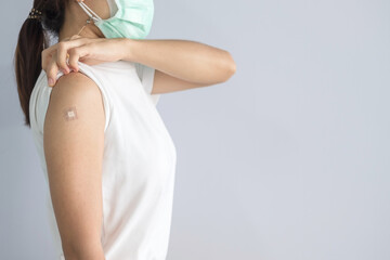 woman showing bandage after receiving covid 19 vaccine. Vaccination, herd immunity, side effect, booster, vaccine passport and Coronavirus pandemic