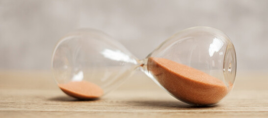 Hourglass on table, Sand flowing through the bulb of Sandglass measuring the passing time....