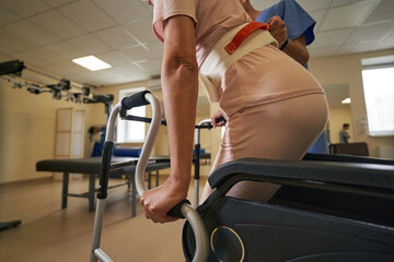 Woman with physical disability using walking frame indoors