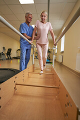 Professional physiotherapist working with mature woman in rehabilitation center