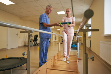 Physiotherapist with stroke patient during balance training in medical center