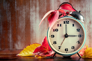 Daylight Saving Time concept, fall back in autumn, with a place for text. A vintage alarm clock...