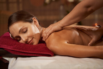 Female spa customer having her back massaged
