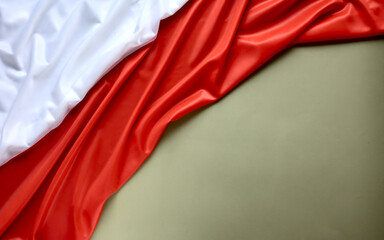 Polish flag on a green (olive) background, copy space. Independence Day November 11, Poland.