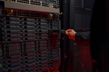 Woman technician removing hard drive at data center