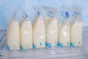 Bags with breast milk on blue background. Milk bank. Expressing breast milk. Breast-feeding....