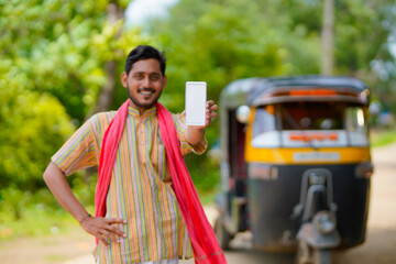 Indian auto rickshaw three-wheeler tuk-tuk taxi driver man showing smartphone