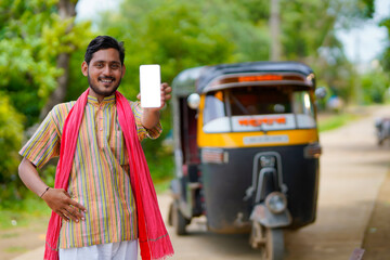 Indian auto rickshaw three-wheeler tuk-tuk taxi driver man showing smartphone