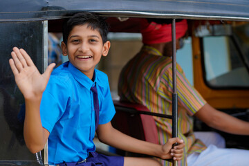 Indian school boy going to school in auto rikshaw