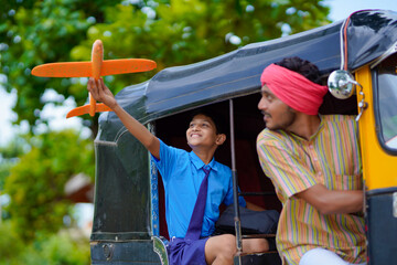 Obraz na płótnie Canvas Indian auto rikshaw or tuk tuk driver with his schoolboy