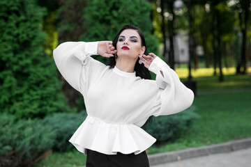 Portrait of a beautiful, young and attractive Caucasian brunette girl. Elegant girl posing in the summer in the park. Fashion concept.